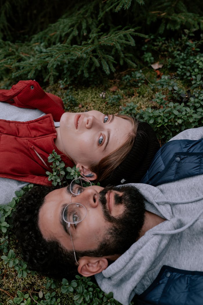 Young couple lying on forest floor, enjoying natures tranquility.